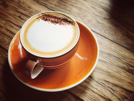 Cup of coffee with froth milk and cinnamon