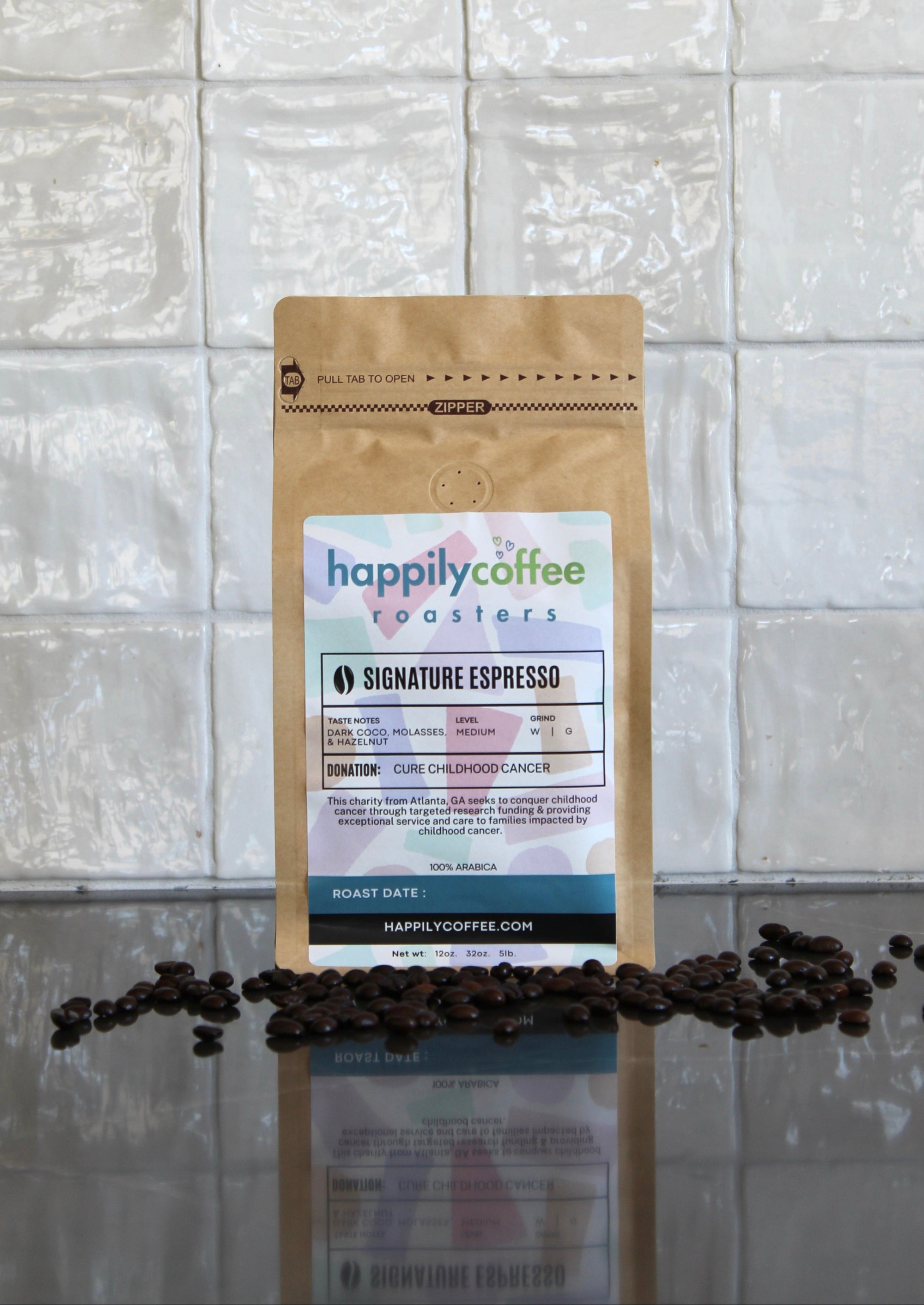 Coffee bag labeled 'happilycoffee roasters' with coffee beans on a reflective surface and tiled wall background