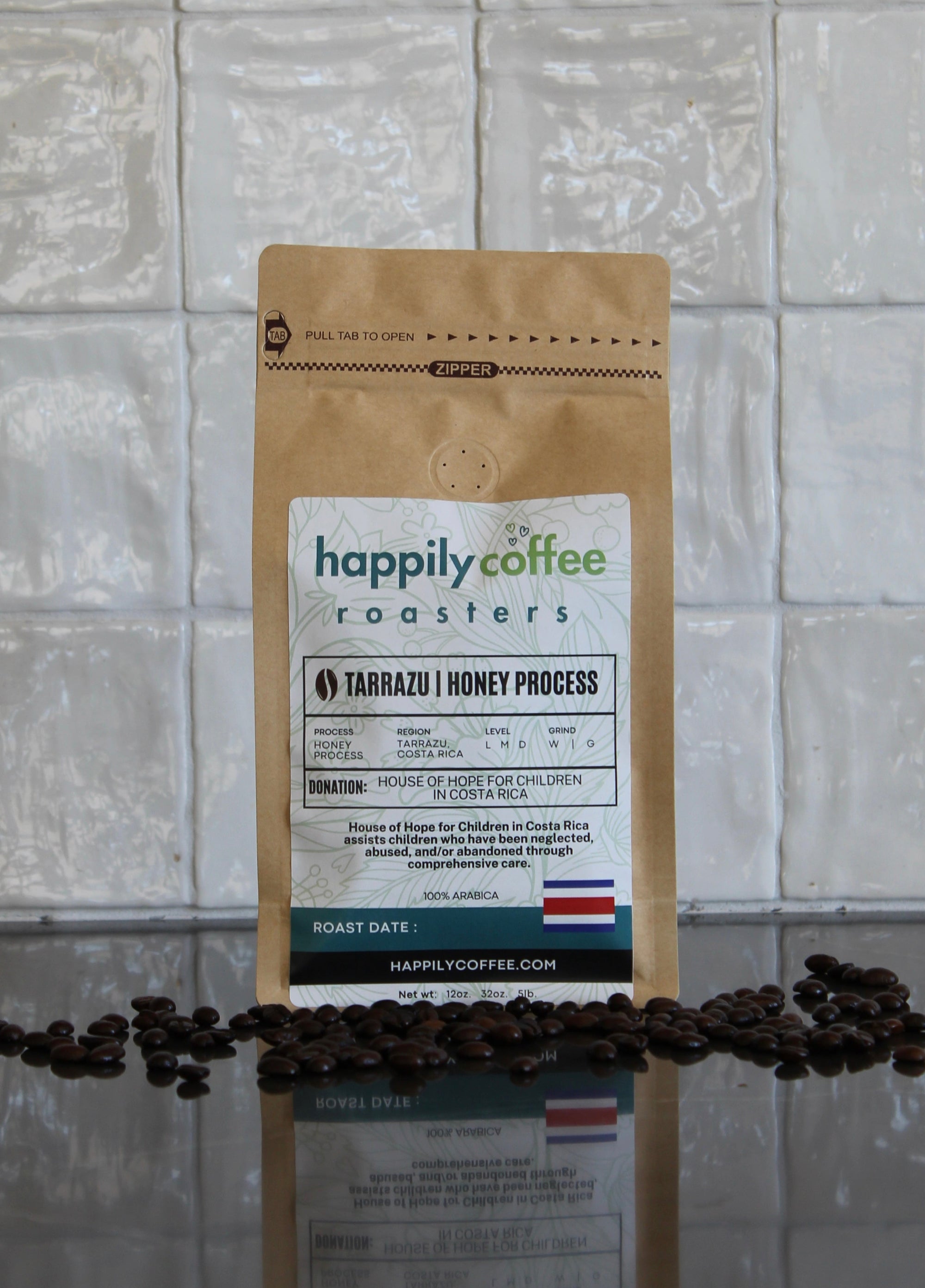 Happily Coffee Roasters package with coffee beans on a tiled floor background