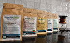 Happily Coffee Roasters packages on a kitchen counter with a tiled wall background